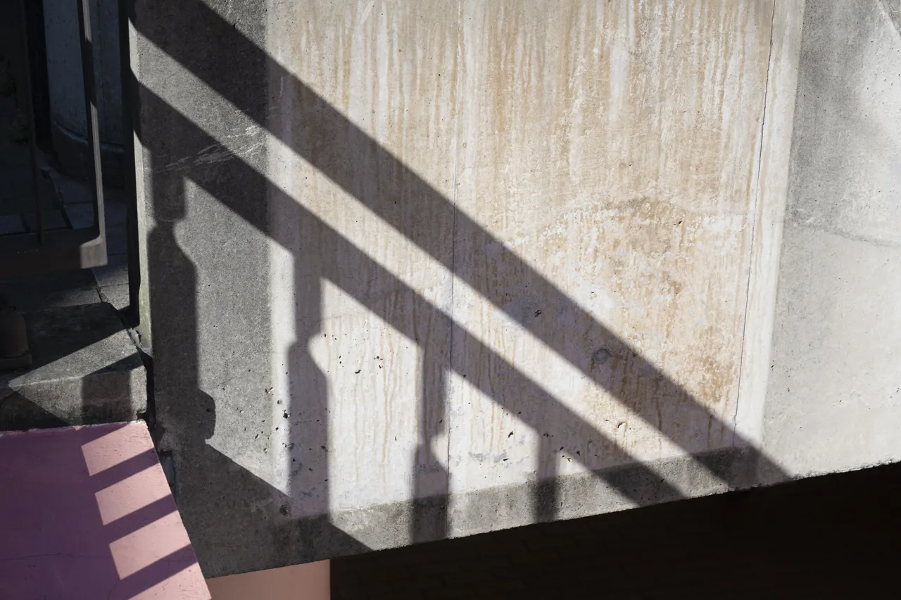 Daylight and geometric shadows across an architectural wall