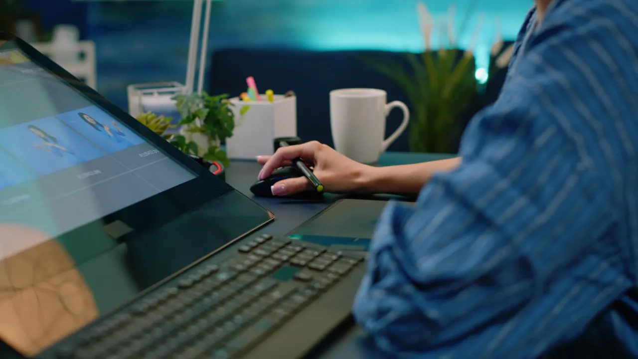 A designer working with a pen tablet and monitor, editorial stock photograph